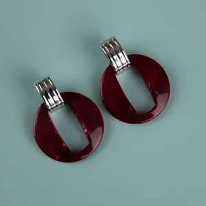Large statement acrylic earrings with silver ribbed connector and dark red marble ring.