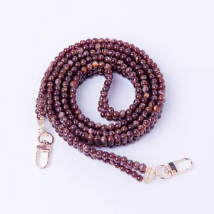 Courroie de sac en perles marron avec fermoirs mousquetons dorés pour sacs et étuis de téléphone.