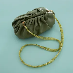 Detailed view of green leather cloud clutch bag with unique acrylic beaded triple chain strap.