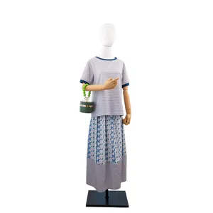 Women striped top skirt outfit with green bead handle cylinder handbag detail view.
