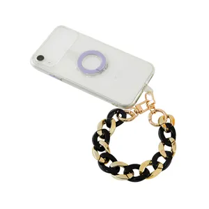 Clear phone case with chunky black gold acrylic chain strap and purple ring holder accessory.