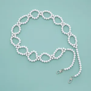 Detail shot of white beaded chain strap with metal clasps for bags and phone decoration.