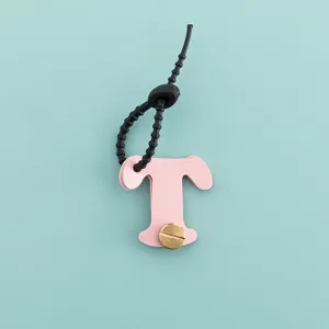 Vue détaillée du porte-clés lettre T en cuir PU rose et pendentif de sac charmant.