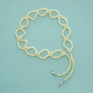 Close-up detail of the woven beaded chain strap featuring interlocking loops and metal clasps.