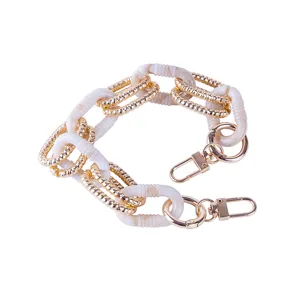 Close-up detail of the DIY acrylic and metallic gold chain link connector for phone case or bag strap.
