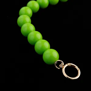Detailed close-up view of vibrant green round bead handbag strap with polished gold metal clasp.