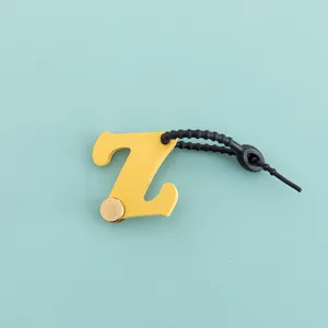 Vue détaillée du charm de sac lettre Z en cuir PU jaune avec cordon noir et bouton.