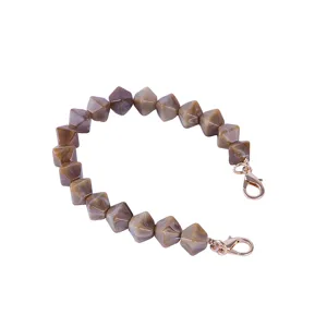 Acrylic faceted bead handbag chain detail showing the marble texture and gold clasps.