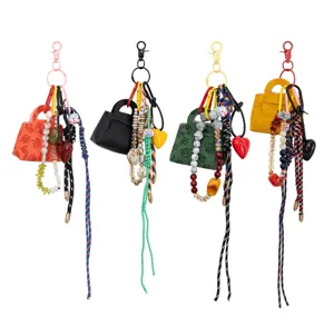 Portachiavi con ciondolo borsa in pelle PU con perline di cristallo e corda intrecciata.