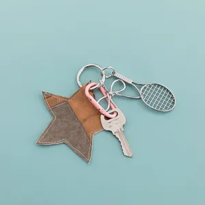 Star leather keychain with tennis racket metal pendant, detailed view of cute bag charm accessory.