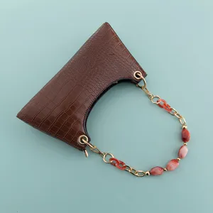 Detail view of the brown crocodile pattern shoulder bag with a stylish beaded chain handle.