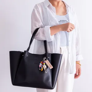 Stylish black tote bag for women with colorful beaded keychain charm for daily casual use.
