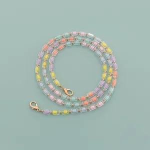 Colorful beaded bag chain detail view, pastel acrylic cylinder beads with gold clasps.