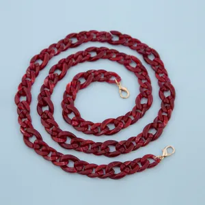 Red acrylic bag chain detail, 120cm crossbody strap with gold lobster clasps, stylish accessory.