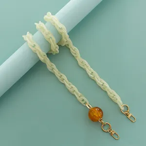 Catena in resina acrilica con perla ambrata e ganci dorati per borse e custodie.