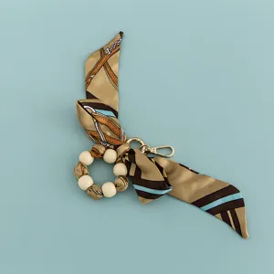 Close-up detail of the creative silk scarf beaded keychain accessory with wooden beads.