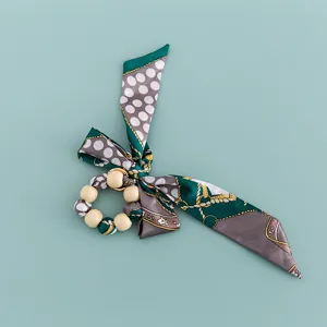 Detailed view of wooden beads silk scarf bow keychain charm with classic pattern.