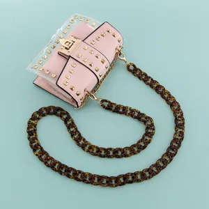 Sac bandouliere transparent rose avec clous et chaine elegante en ecaille pour femmes.