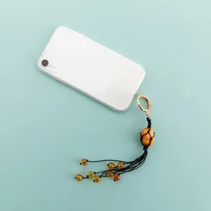 Handmade woven rope net stone bag charm keychain detail view showing amber stone and beads.