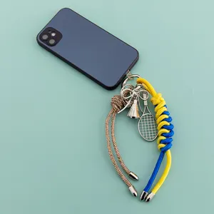 Detailed view of the sports themed alloy keychain with tennis racket and bow charm.
