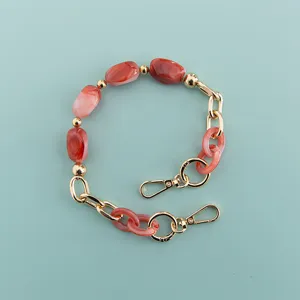 Details of the red marbled bead and gold hardware short phone case chain for daily use.