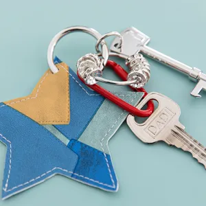 Handmade star PU leather keychain detail shot, beautiful blue and yellow color block bag charm.