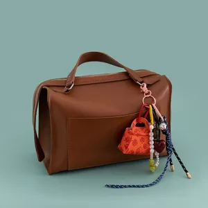 Borsa a mano in pelle PU marrone con ciondoli chic, ciondolo mini borsa e portachiavi con perline.