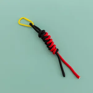 Detailed view of handmade black red paracord bag charm with yellow mini metal carabiner.