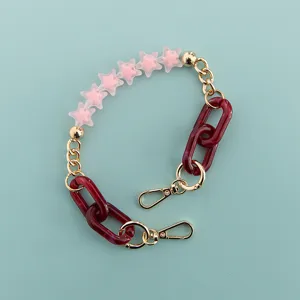 Detailed view of pink frosted star beads and dark red resin links on chic phone chain strap.