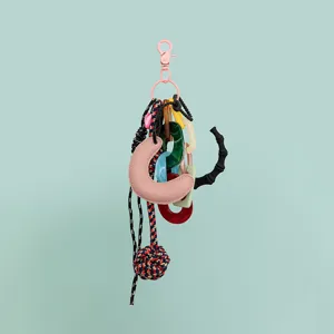 Details of DIY bag charm featuring pink clasp, leather crescent, and colorful links.