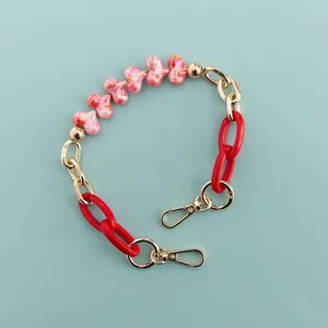 Short phone case chain strap with pink heart beads and red links, chic decorative accessory.
