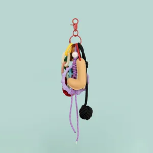Colorful DIY bag charm keychain with leather letter pendant, resin links and woven cords for accessories.