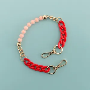Detail view of a 40cm short phone chain with pink beads, red links and gold hardware.