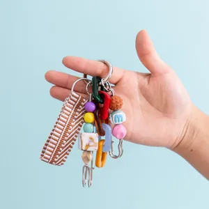 Close-up details of colorful acrylic chain links, woven strap and beaded bag charm keychain.