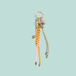 Chic alloy keychain and bag charm featuring knotted pink yellow cords and crystal bow details.