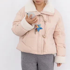 Women's pink winter puffer jacket detail shot showing soft faux fur collar and cozy design features.