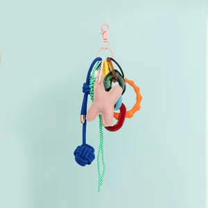 Colorful multi-charm keychain detail, featuring mixed material rings and braided rope.