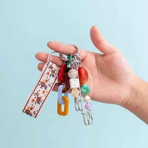 Detailed view of colorful handmade keychain with fabric strap, acrylic links and beads for bags.