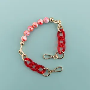 Short decorative phone case chain strap with red beads and gold hardware for daily use.