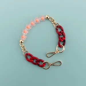 Detailed view of short phone charm chain featuring pink flower beads and red resin links.