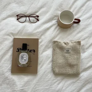 Detailansicht der handgemachten gestrickten Handytasche im ästhetischen Flat-Lay-Stil.