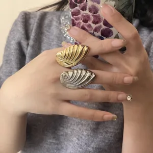 Nahaufnahme der klobigen gerippten Muschel Statement Ringe in Gold und Silber Design.