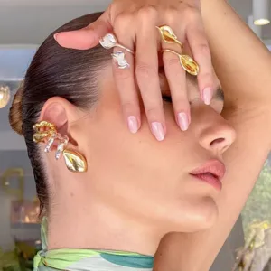 Detailansicht von modischem metallischem abstrakten Ohrclip und verstellbarem Ring Set.
