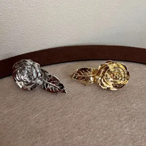 Detaillierte Nahaufnahme von metallischen Rosen-Ringen und Blatt-Design in Gold und Silber.