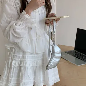 Dettaglio di un portamonete croissant argentato in stile vintage accessorio moda carino.