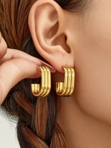 Vista detallada de pendientes de aro cuadrados multicapa chapados en oro con diseño minimalista.