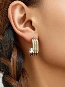 Primer plano de pendientes de aro cuadrados multicapa, acero inoxidable en tonos oro y plata.