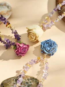Nahaufnahme Detail von Harz Rosen Anhänger und Naturkristall Splitter Perlen Halskette Schmuck.