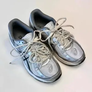 Detailed view of fashionable pearl beaded shoelace decoration accessory, elegant design.