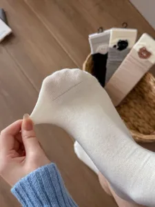 Close up view of the stretchy fabric and fine knit texture of casual women socks detail.